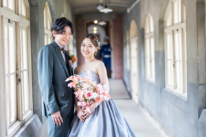 コンクリート調の渡り廊下で自然にほほ笑む新郎新婦