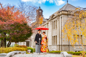 秋色の色打掛に身を包み紅葉する文翔館で撮影する新郎新婦
